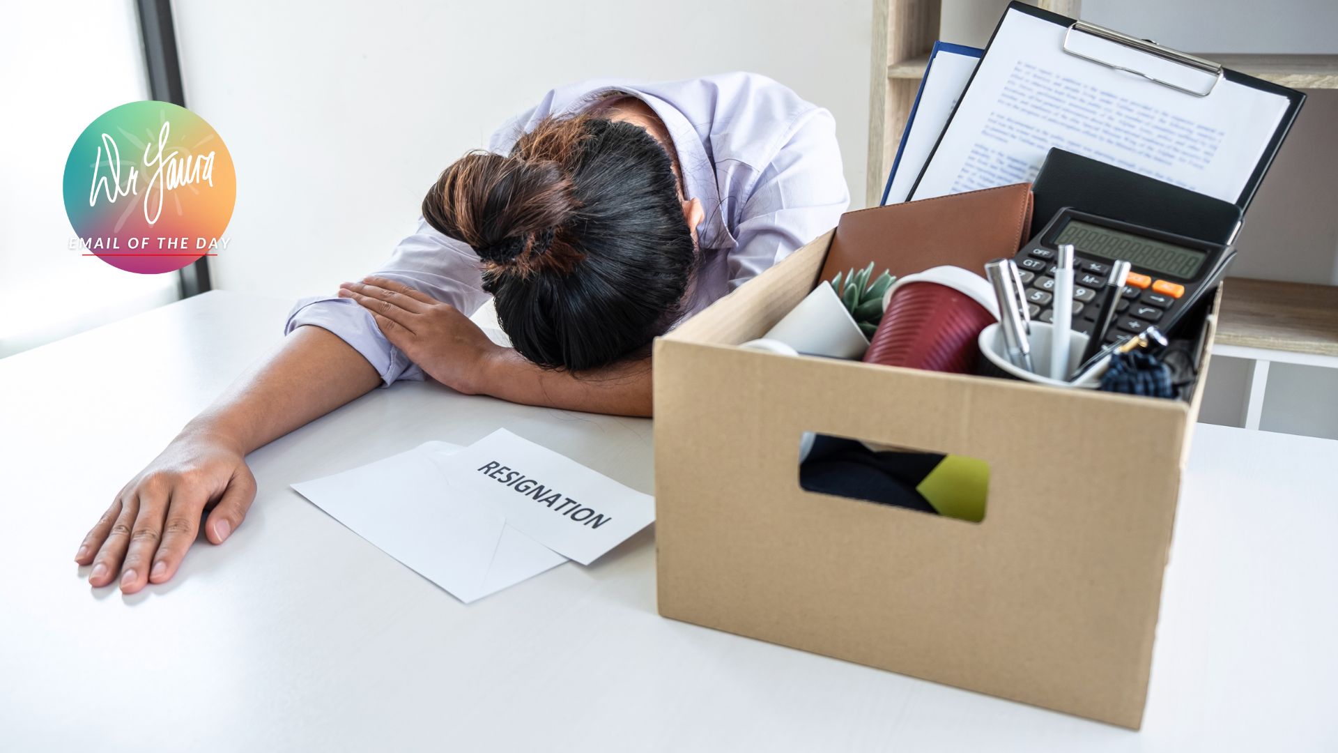 Woman lays head on her desk with a moving box next to her