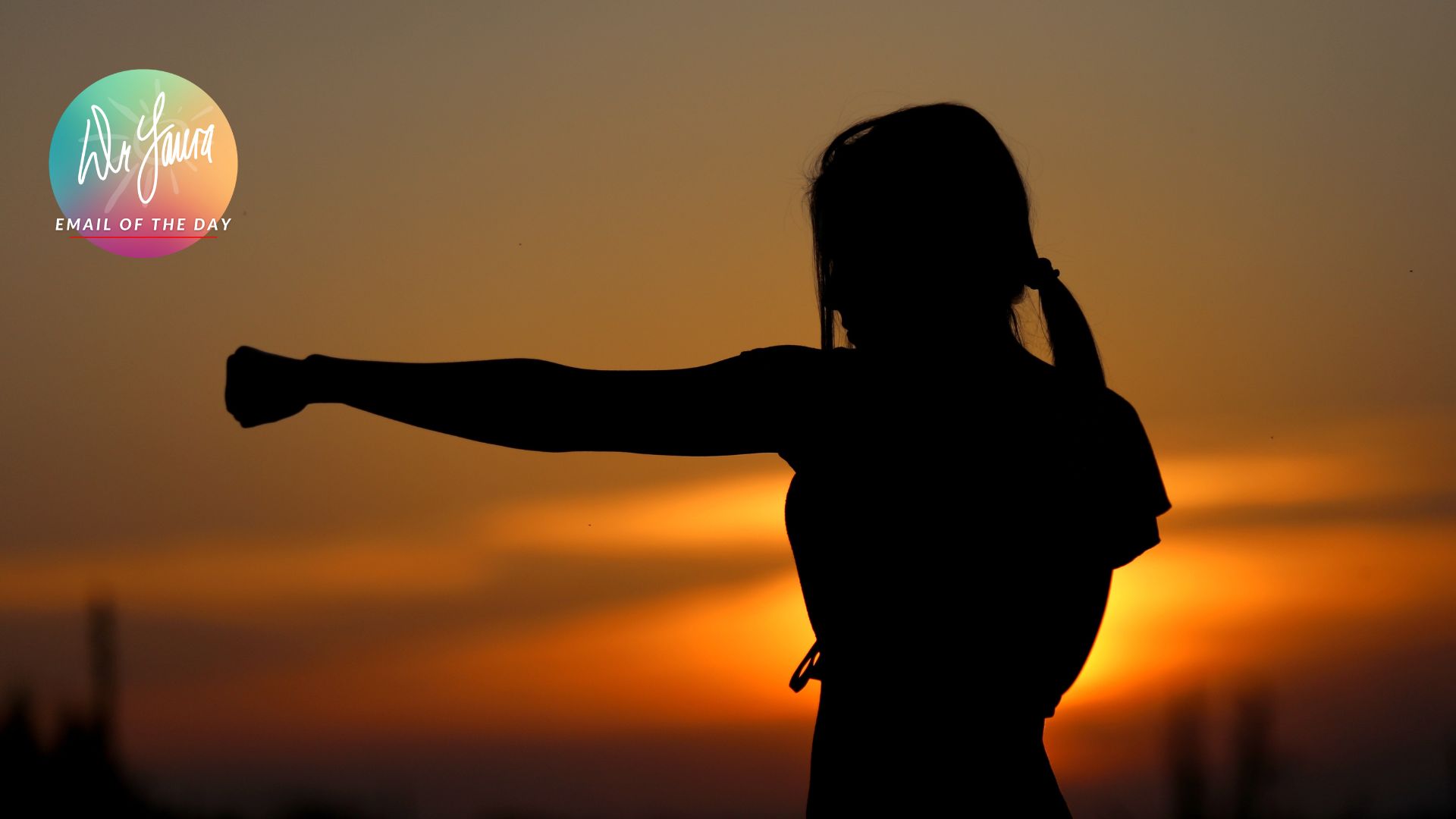 Silhouette of woman punching the air in the backdrop of a sunset