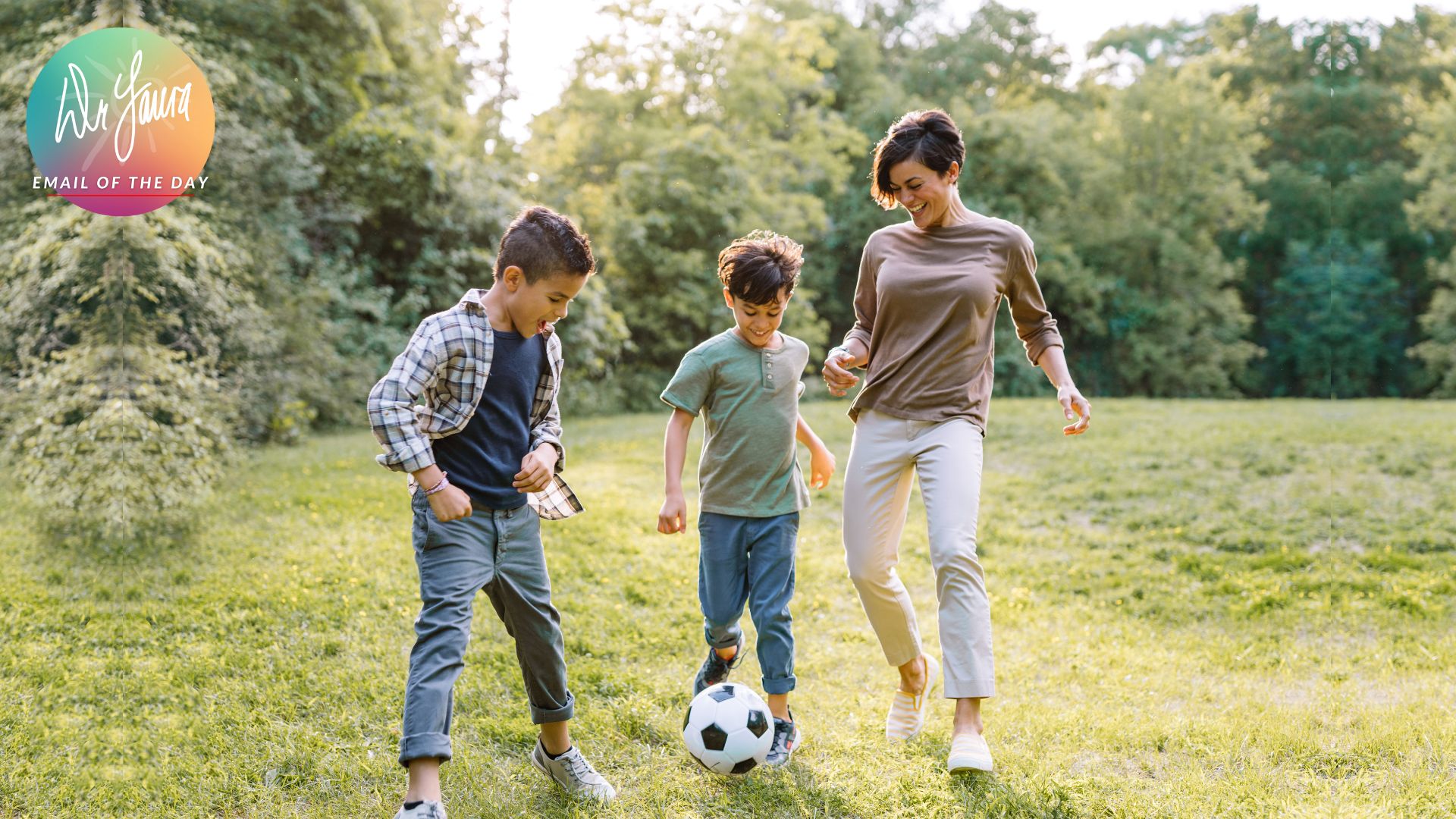 Mom kicks soccer ball outside with two young boys