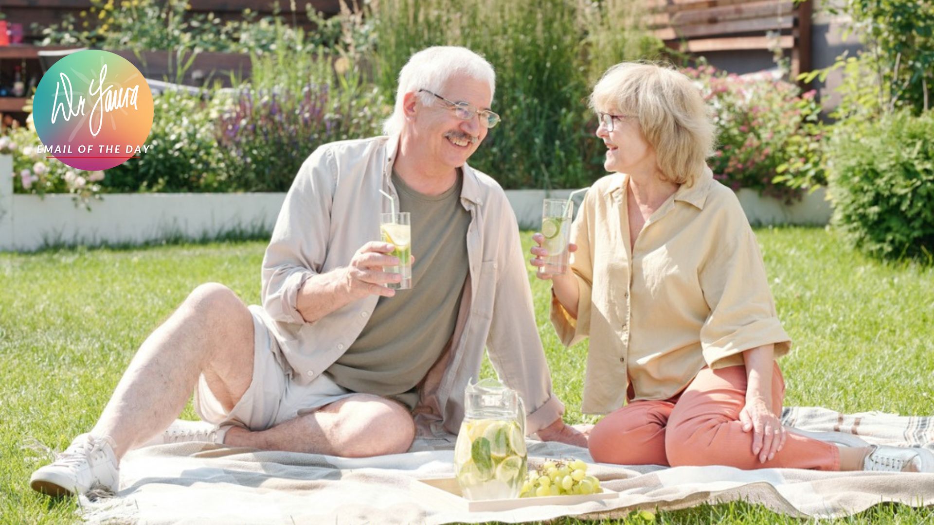 Man in green shirt sits next to woman in beige button up on a picnic blanket outside