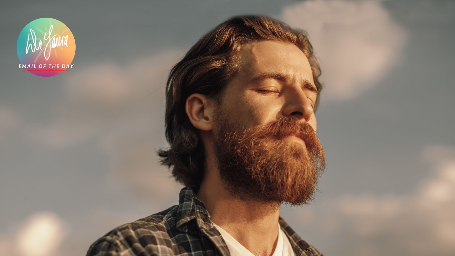 Man with ginger hair and beard wearing plaid shirt closes eyes and looks up