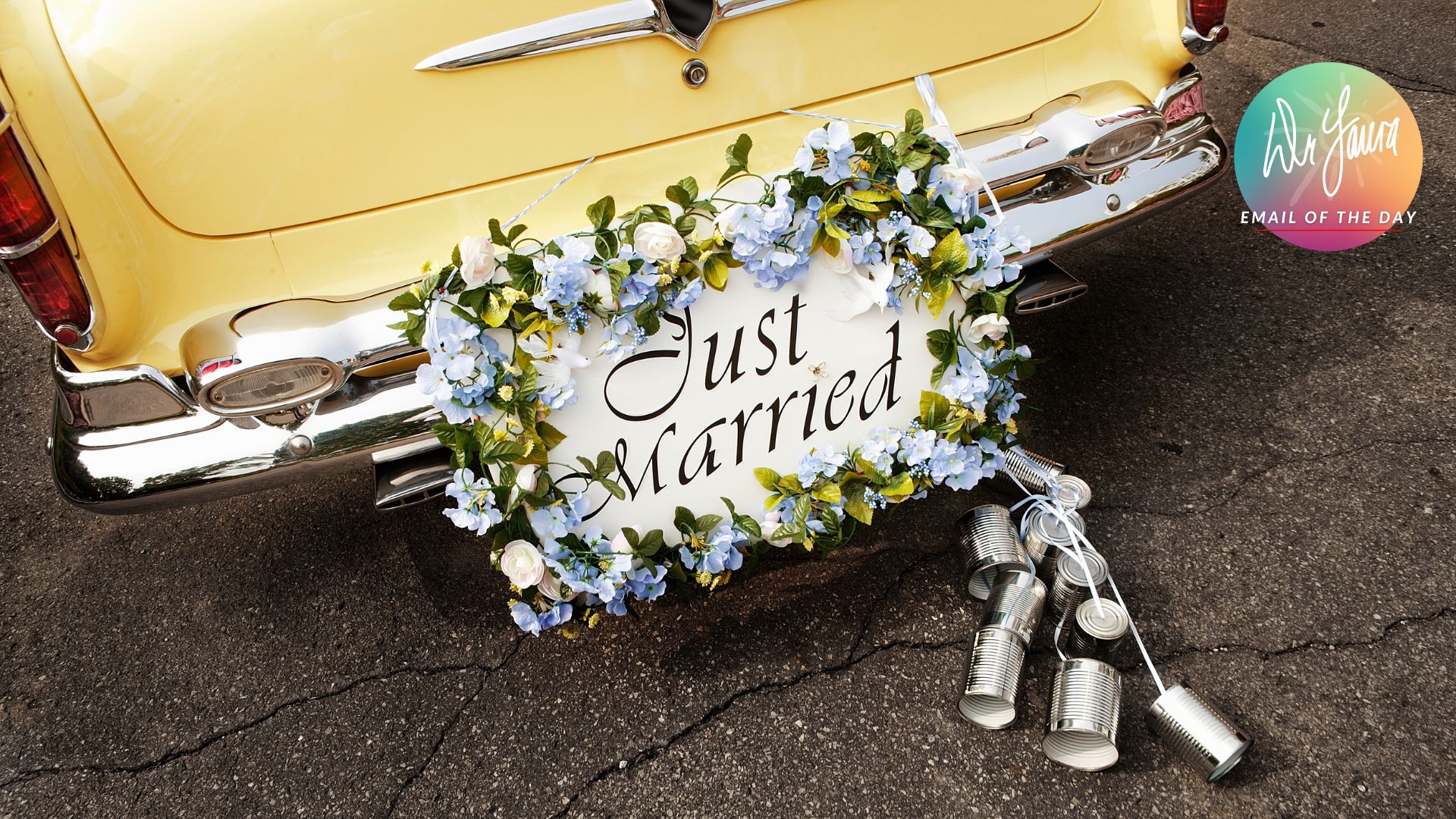 Image of yellow car with license plate reading "Just Married" and decorated with blue flowers and several tin cans tied to it