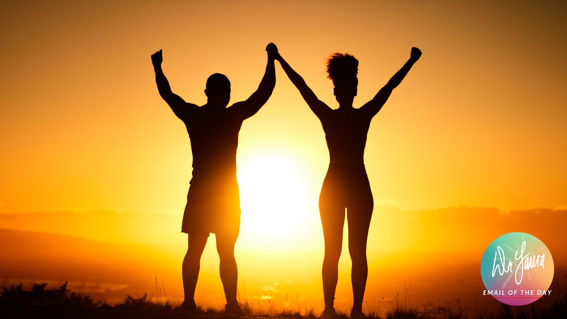 Silhouette of man and woman holding raised hands with sunset background 