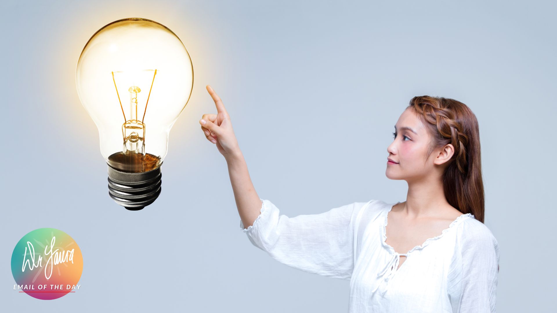 Woman touches large light bulb next to her