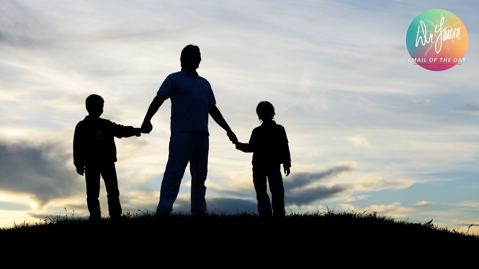 Silhouette of man holding onto the hands of two boys while standing atop a grassy field