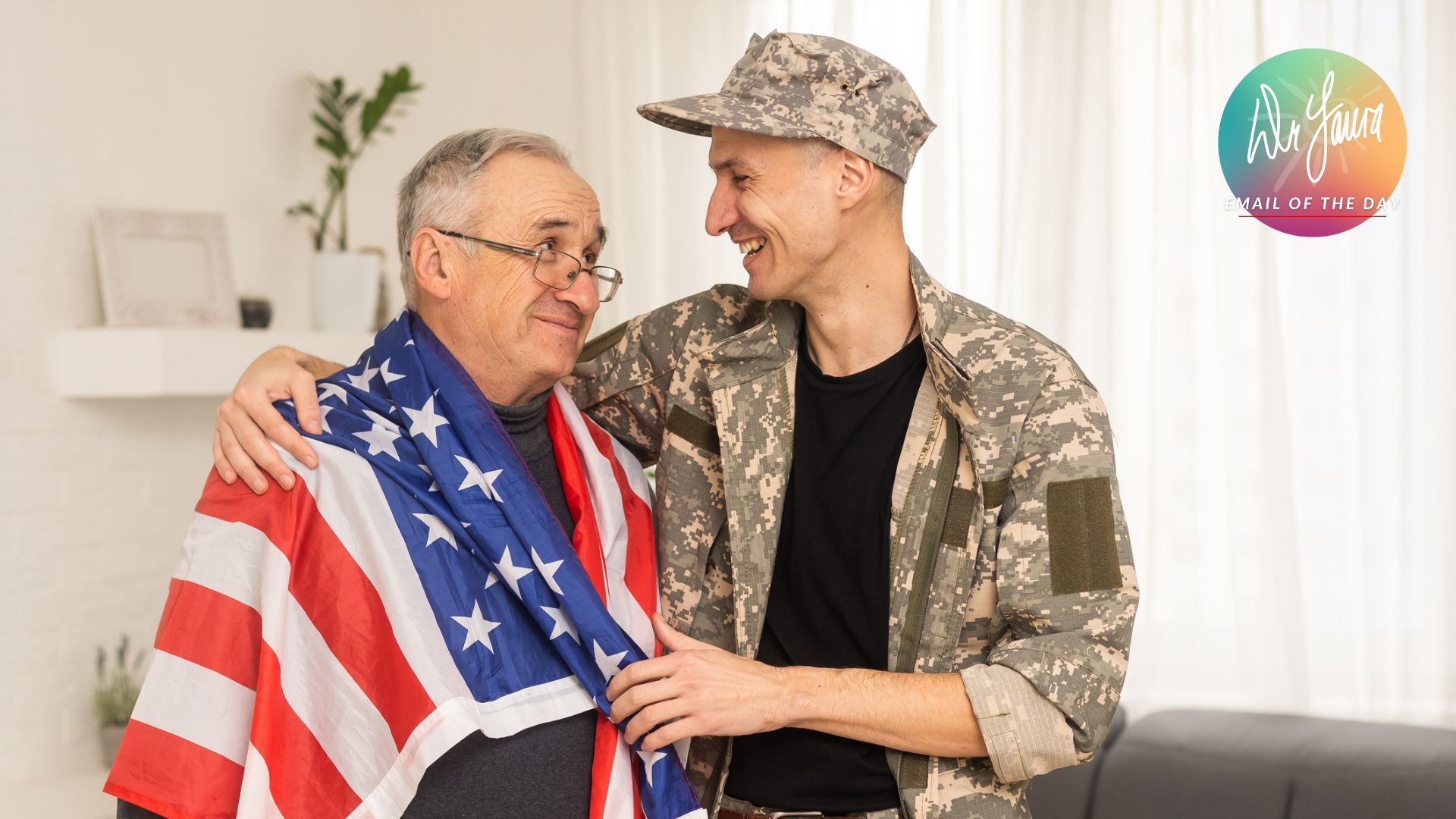 Man in soldier's uniform embraces older man with American flag wrapped around his shoulders