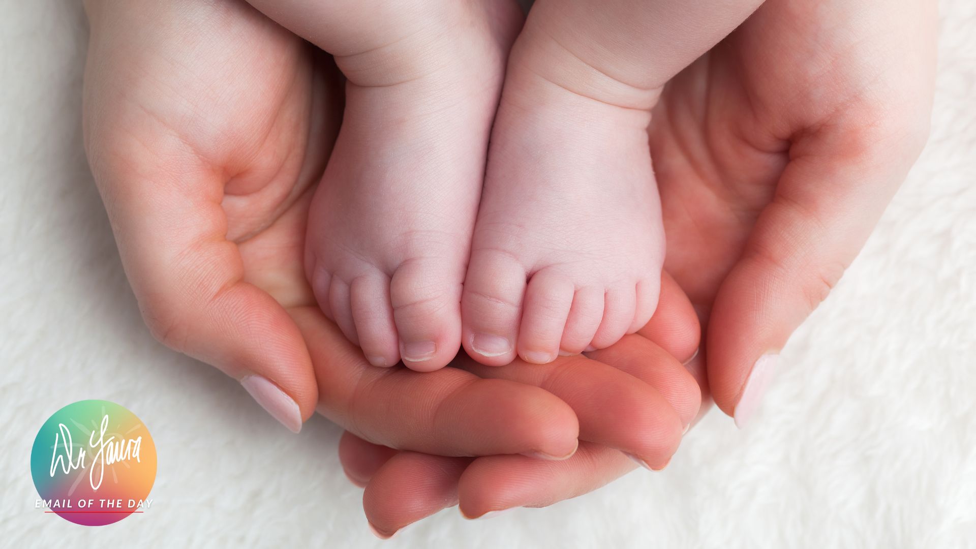 Adult hands cup and hold an infant's feet