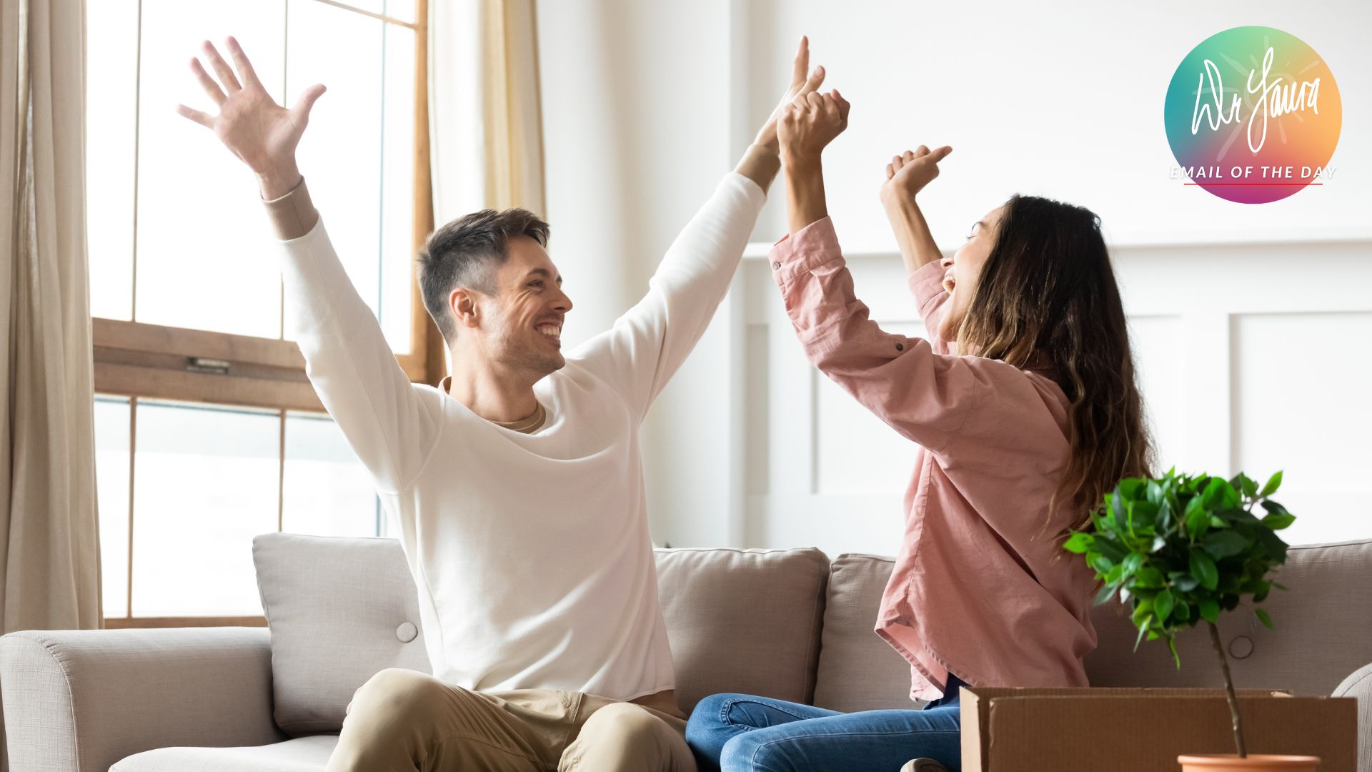 Man raises arms up while sitting next to woman with arms raised up next to him