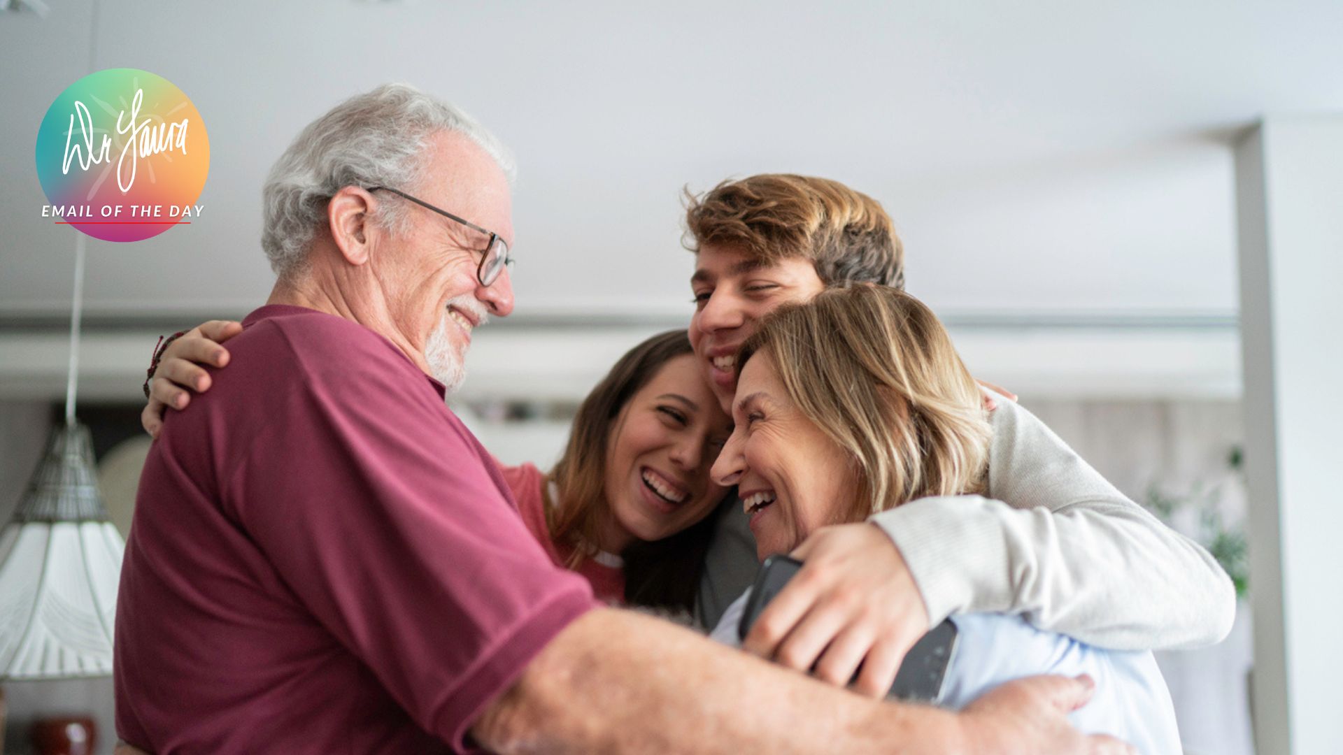 Older man embraces an older woman, male teen and female teen