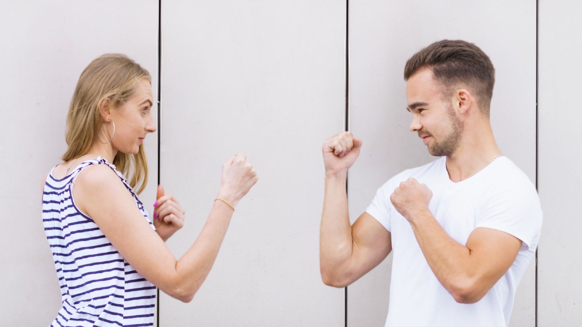 Man and woman face each other with their fists raised